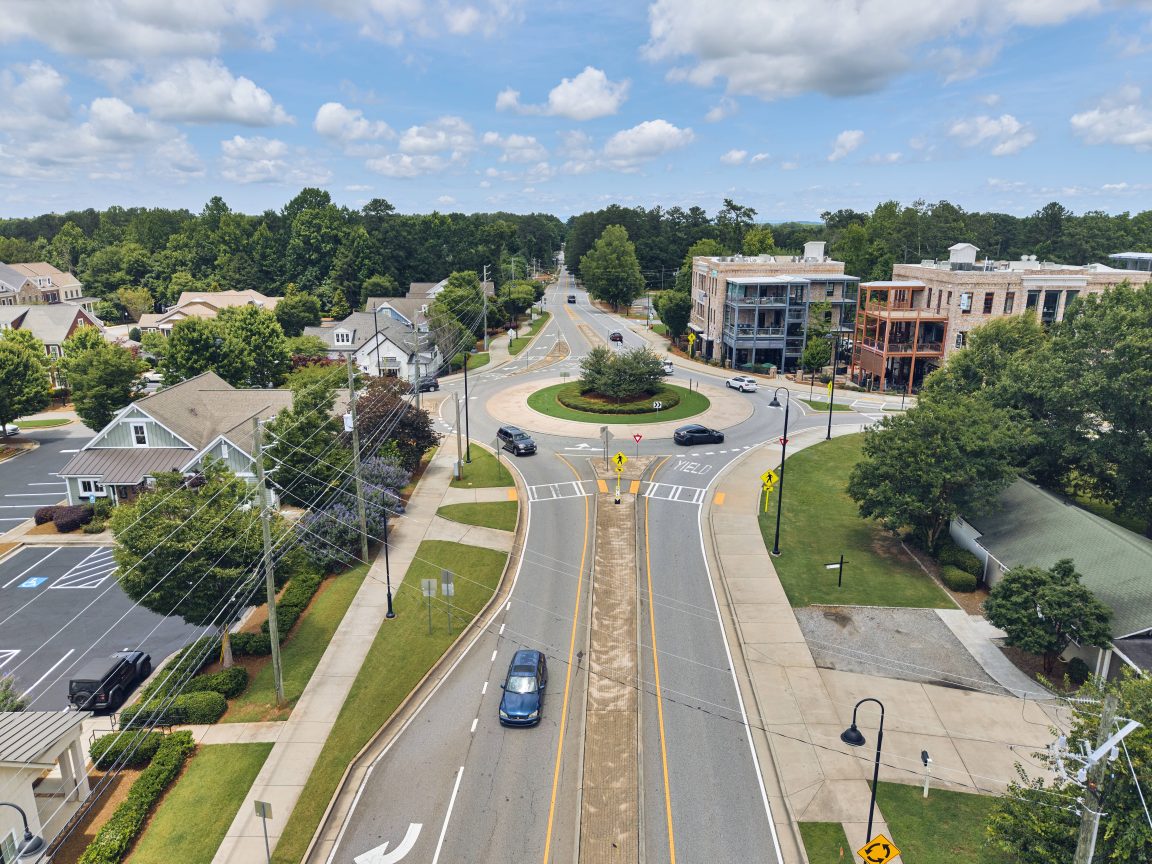 Aerial view of Milton, foxused on a main road, miles of trees and an eventual highway system.