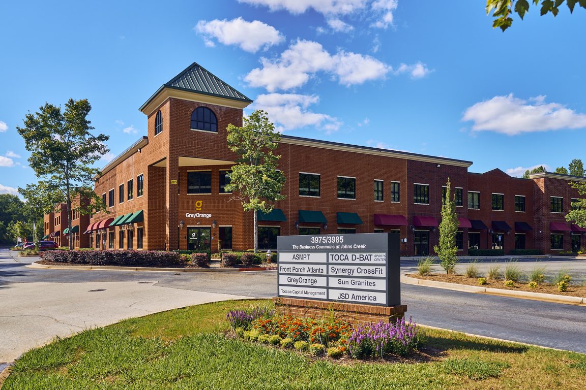 A corner view of a brick building that is part of a John's Creek office park.